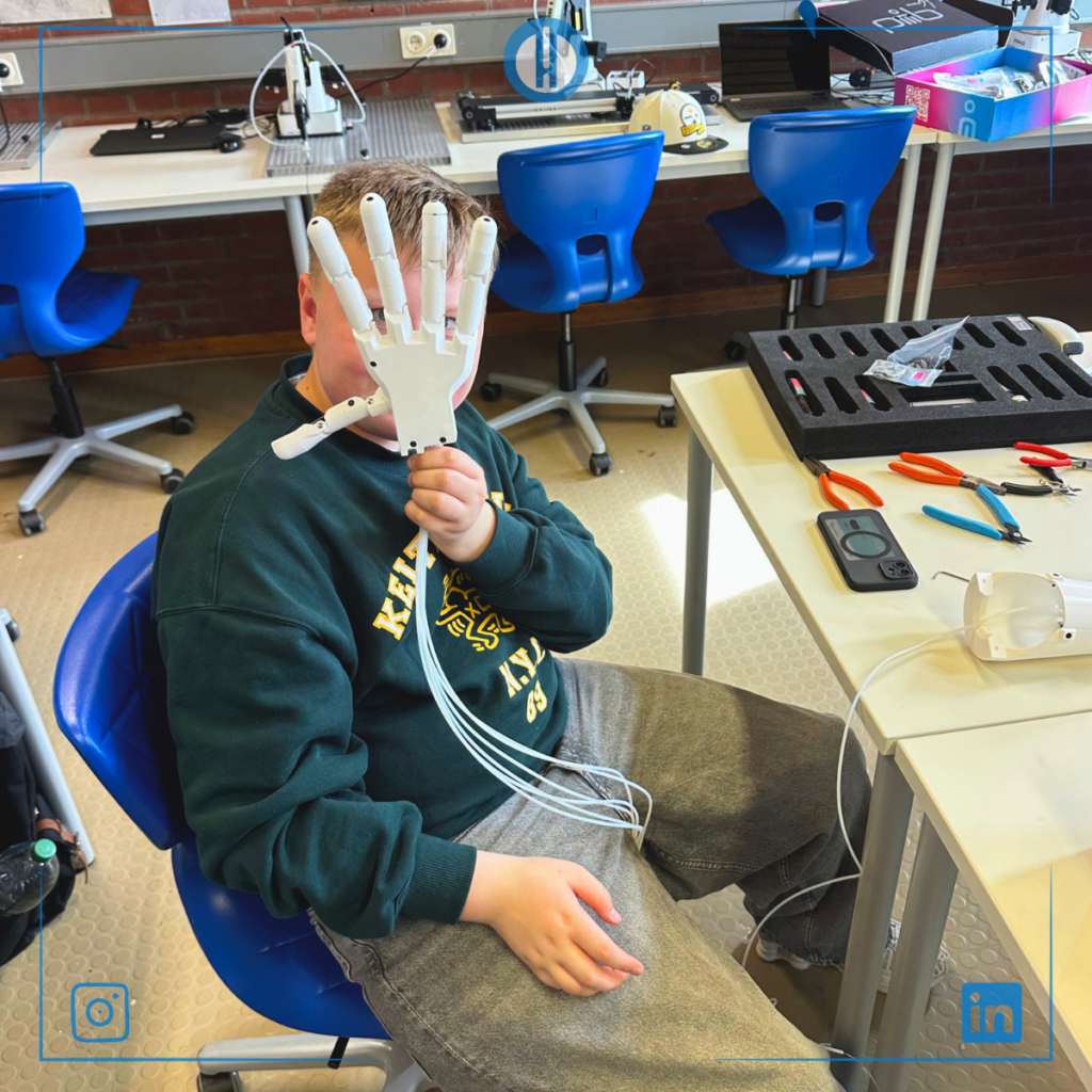 Child holding a 3D-printed robotic hand in a workshop, surrounded by tools and equipment for hands-on learning.