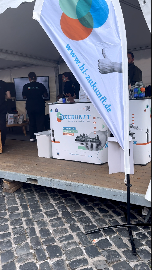 Flag at a booth promoting hiZukunft, showcasing resources for future career opportunities and innovation.