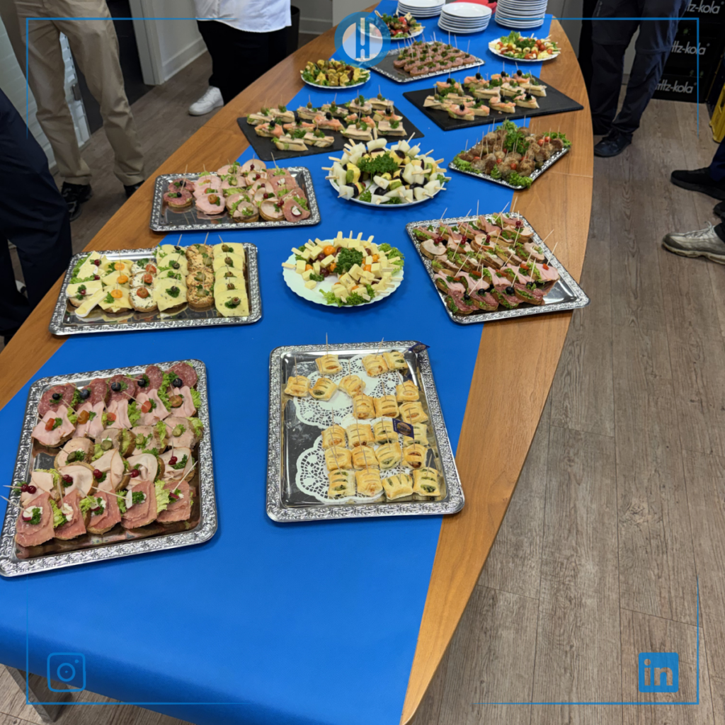 Catering spread featuring an array of appetizers on a blue tablecloth at a professional event.